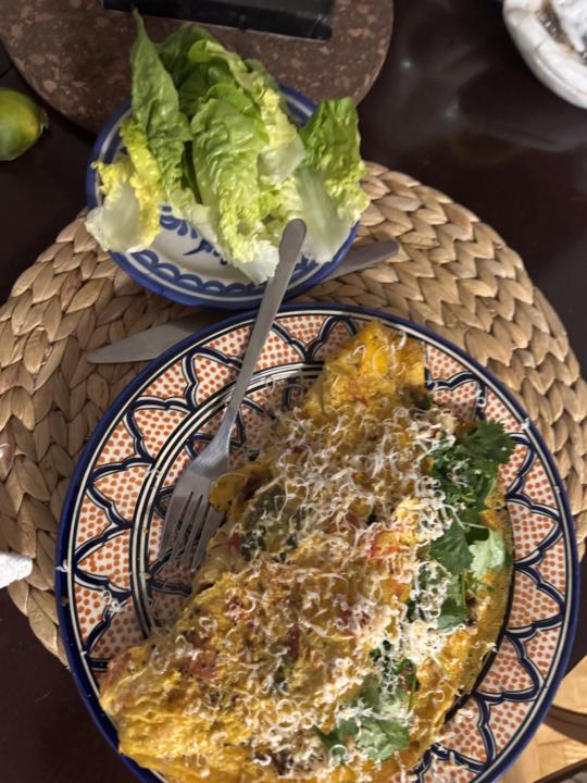 Omelette de cebolla y tomate relleno de pollo, taboule, cilantro y salsa verde picante